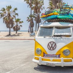阳光明媚的春日，黄色货车车顶上堆放着冲浪板。威尼斯海滩，美国加州。图片由Adobe Stock授权，作者为Rawf8。